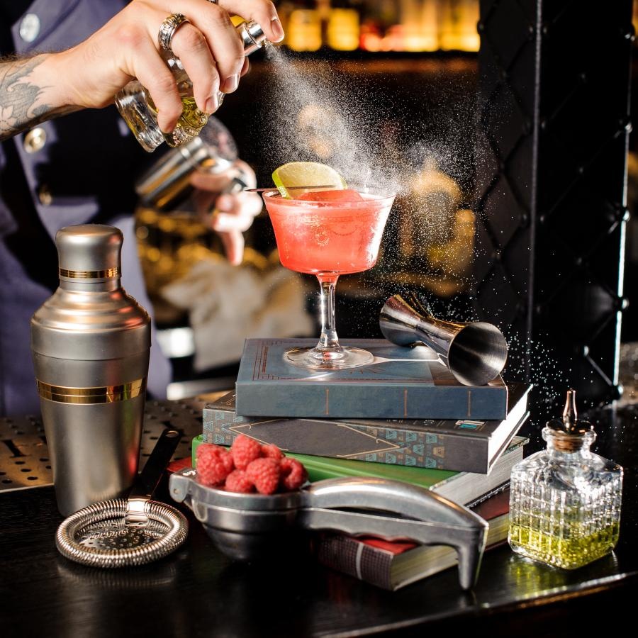 a person pouring a drink into a glass