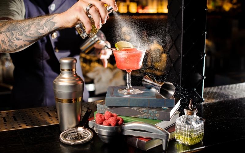 a person pouring a drink into a glass